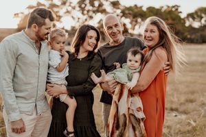 A joyful extended family portrait in casual attire at golden hour.