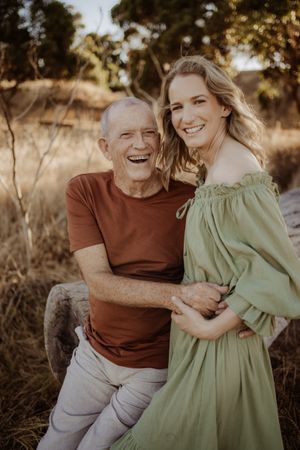 A candid moment captured between two people laughing together in warm sunlight.