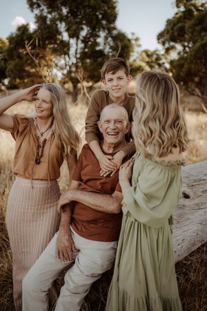 A group shares laughter during a casual outdoor portrait session at sunset.