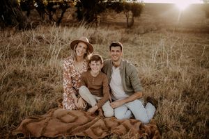 A couple shares an intimate moment together in a rustic outdoor setting during golden hour.