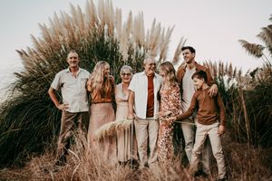 Group portrait session in front of tall pampas grass during golden hour.
