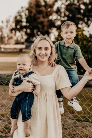 Casual outdoor portrait session with group members by chain link fence.
