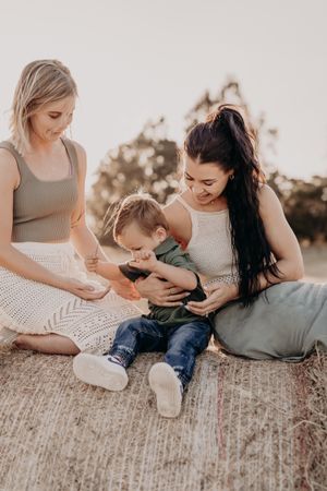 Intimate family moments captured during casual outdoor photo session in field.