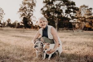 Group poses with pet dog during outdoor sunset photo session.