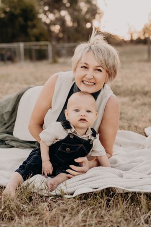 Candid moments of parent and young child relaxing on a white blanket outdoors.