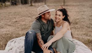 Romantic couple photos taken on blanket in rustic outdoor setting.