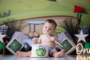 Green themed first birthday photo shoot with nature-inspired decorations.