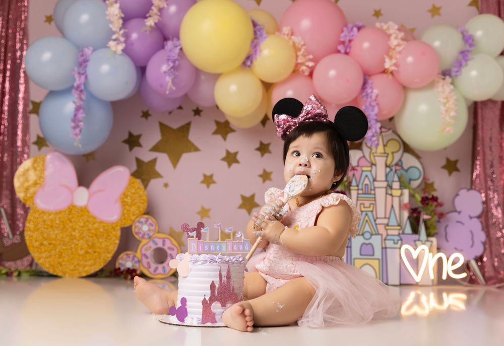 Pastel balloon arch with stars and glitter for first birthday celebration photoshoot.