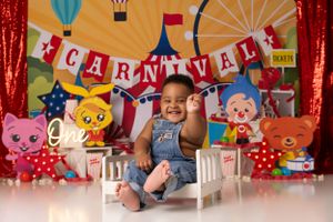 Carnival-themed photo backdrop with colorful banners and festive decorations.