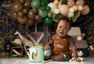 Safari themed cake smash photography with mint green cake and balloon arch.