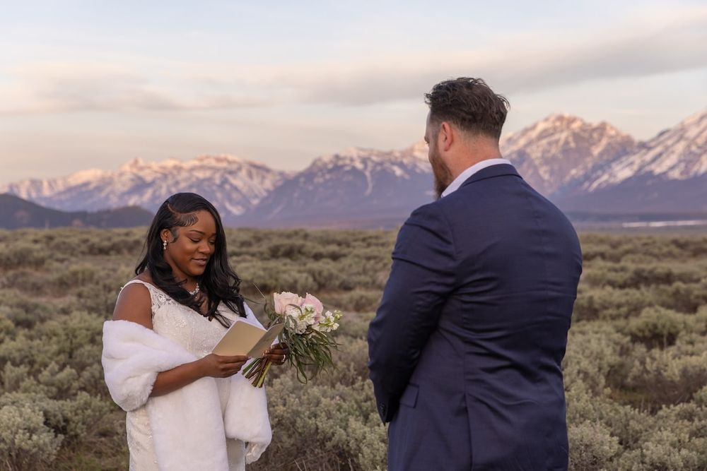 Couple celebrates their wedding against dramatic mountain landscape in rugged mountain terrain at sunset.