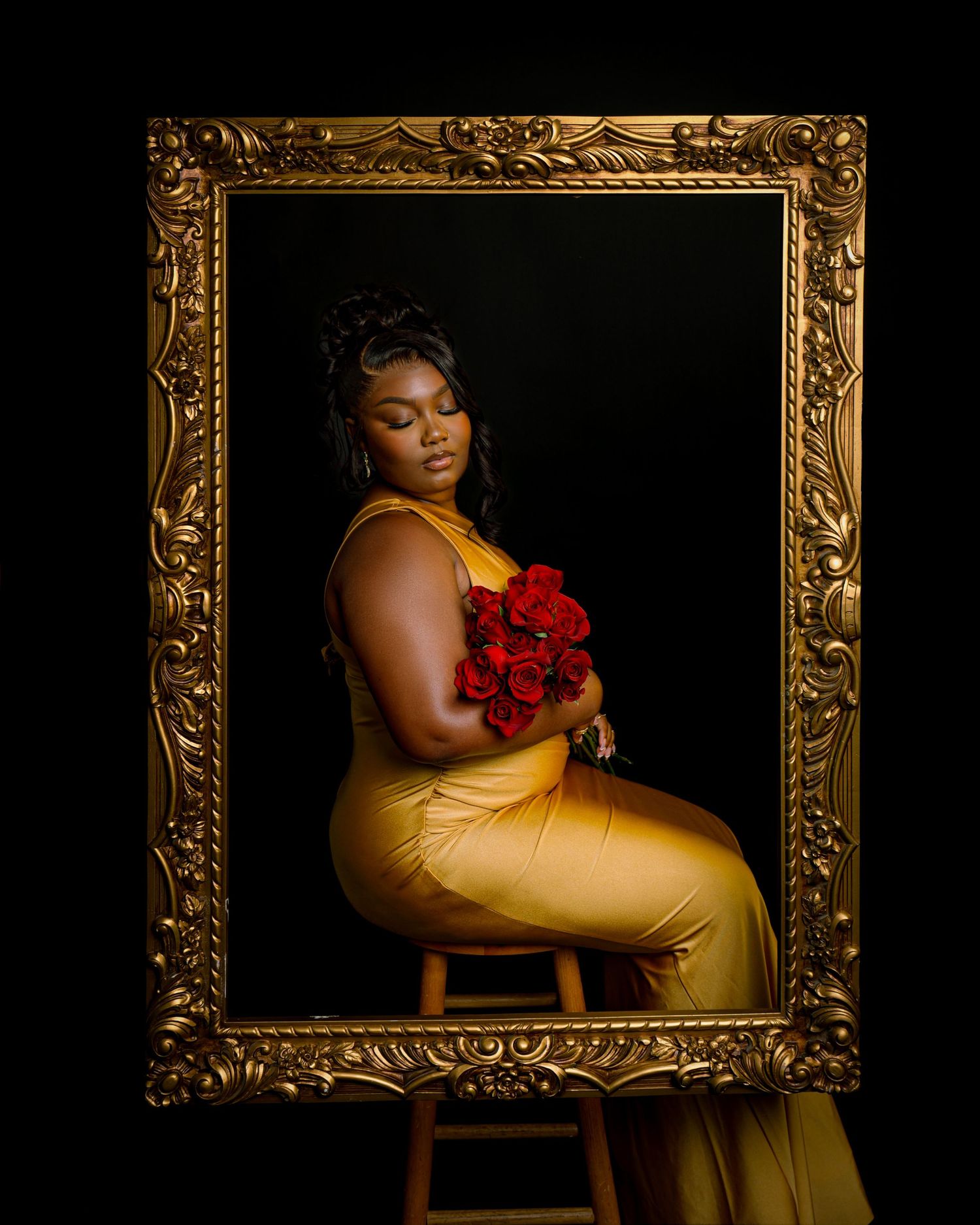 Elegant portrait in gold frame featuring person in yellow dress holding red roses.