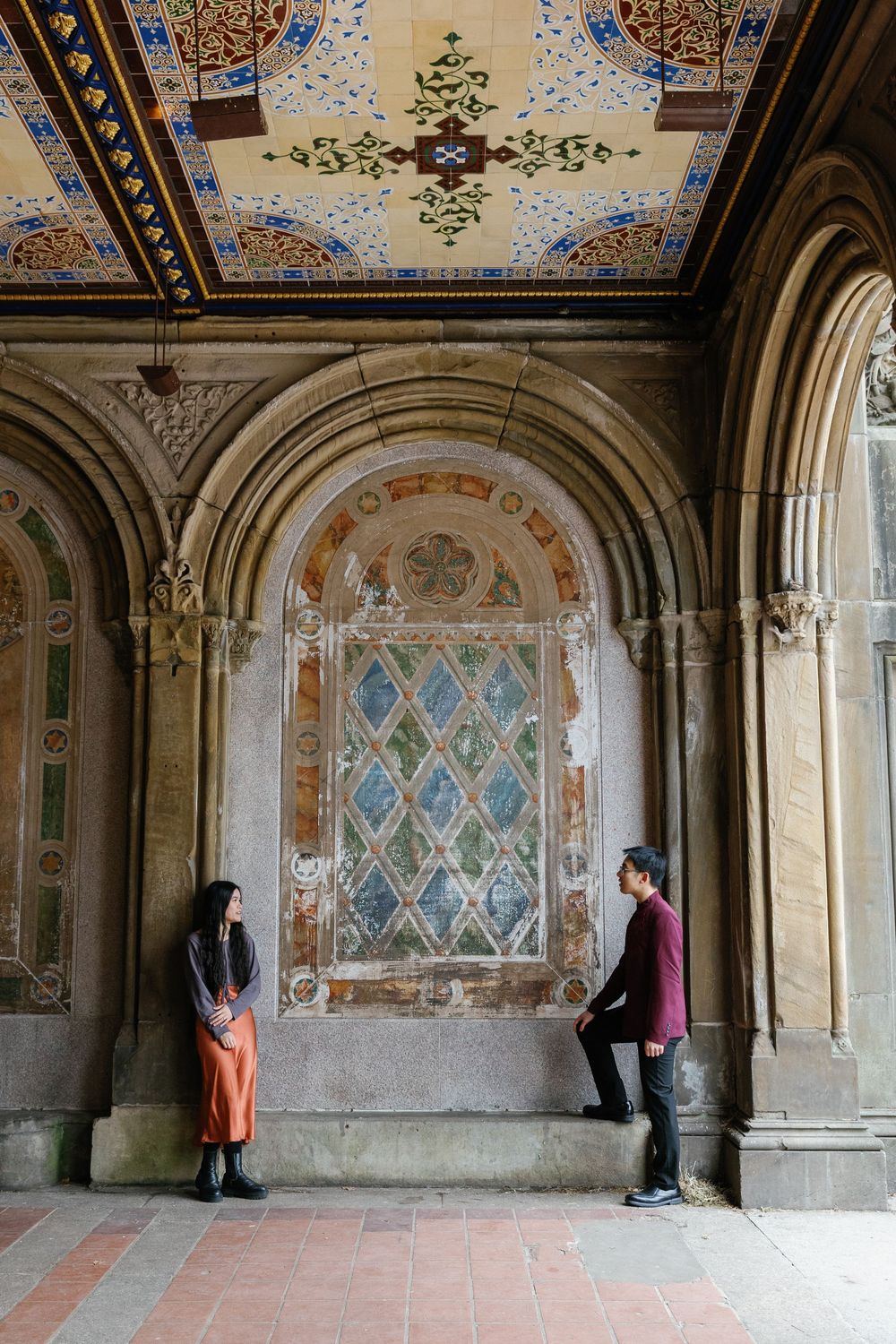 People stand in Central Park's Bethesda Terrace arcade with its ornate Minton tile ceiling and stone archways.