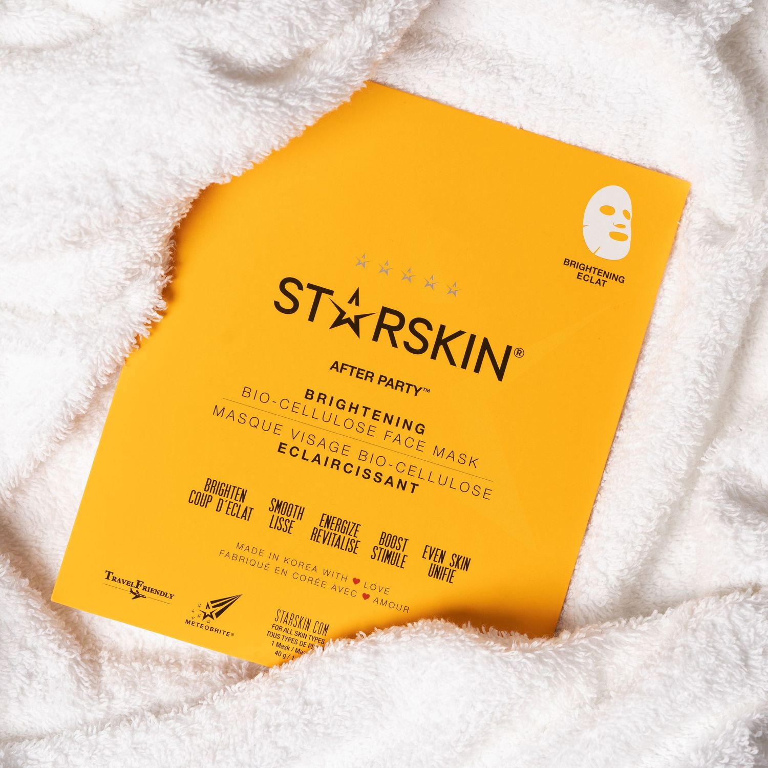 Een lichte productfoto van een beautyproduct, de verpakking is gewikkeld in een wit laken.
