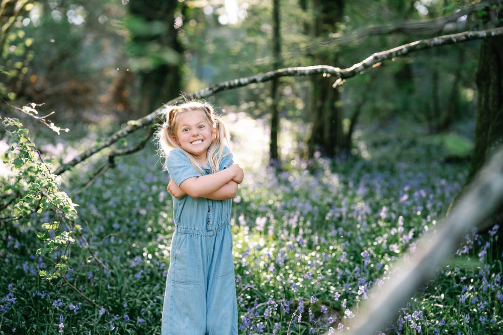 Children playing in a blooming garden with natural sunlight filtering through trees.