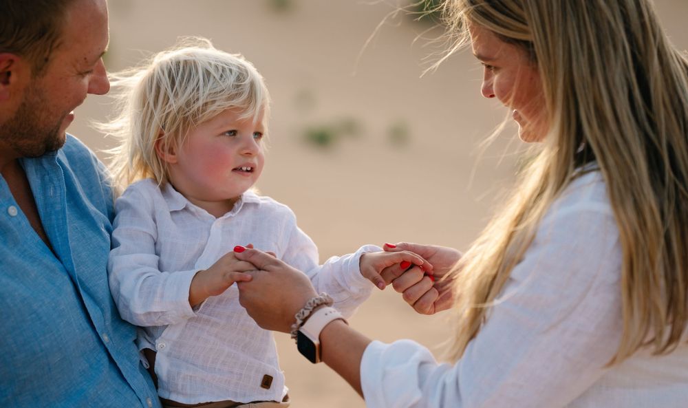 Family enjoying a casual outdoor photoshoot in casual attire with natural expressions.