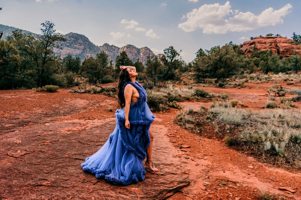Royal blue gown contrasts beautifully with red desert landscape and mountain backdrop in Sedona.
