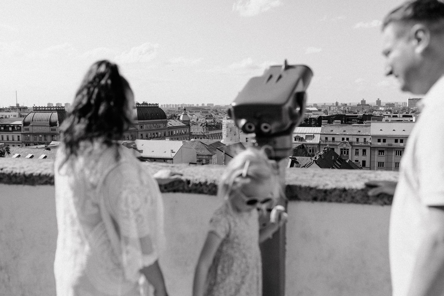 Charming family portrait, slightly out of focus, while the vibrant cityscape of Zagreb is in the background.