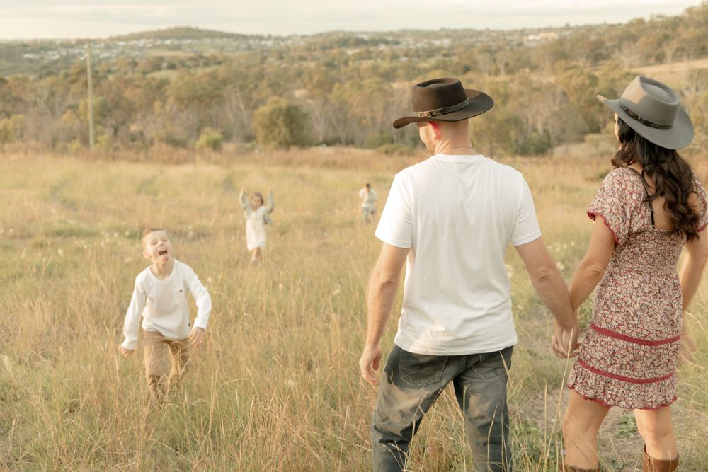 Family members spread out across a golden field during an outdoor photo session.