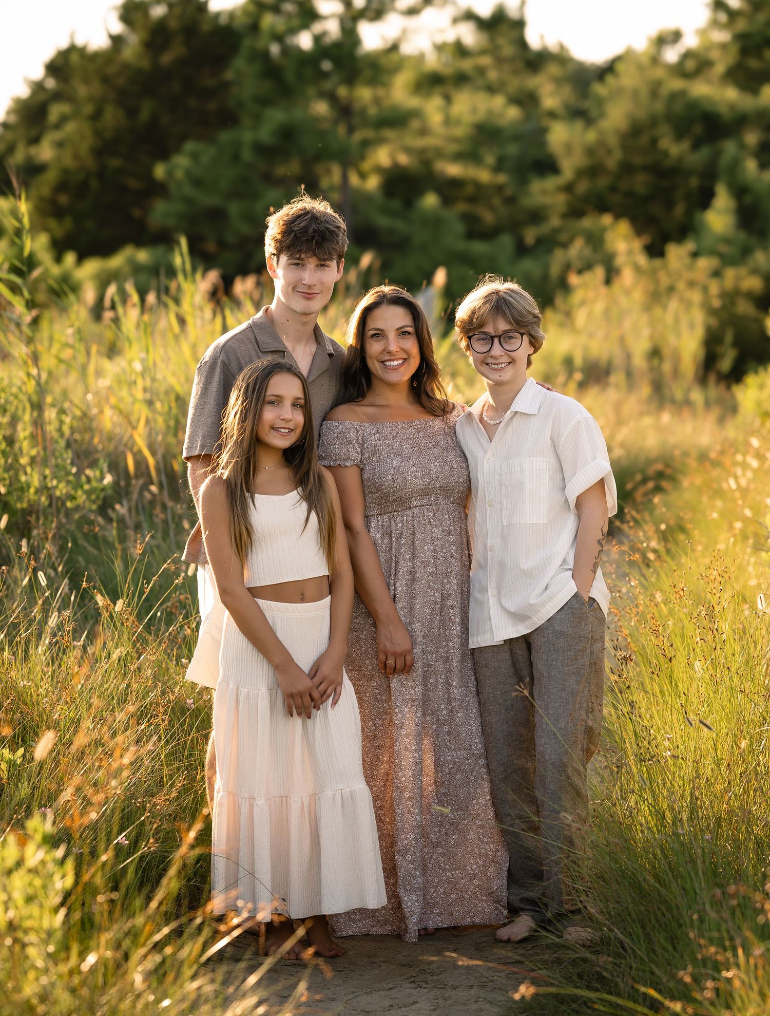 A family relaxes together in a grassy field during an outdoor photo session.