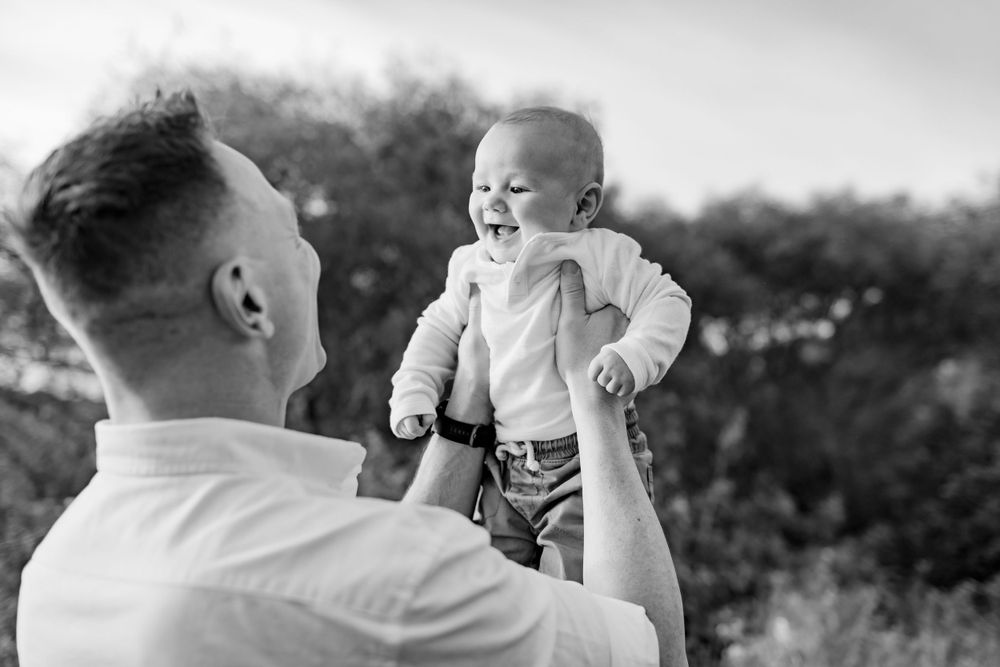 A heartwarming moment of play and laughter captured in black and white.