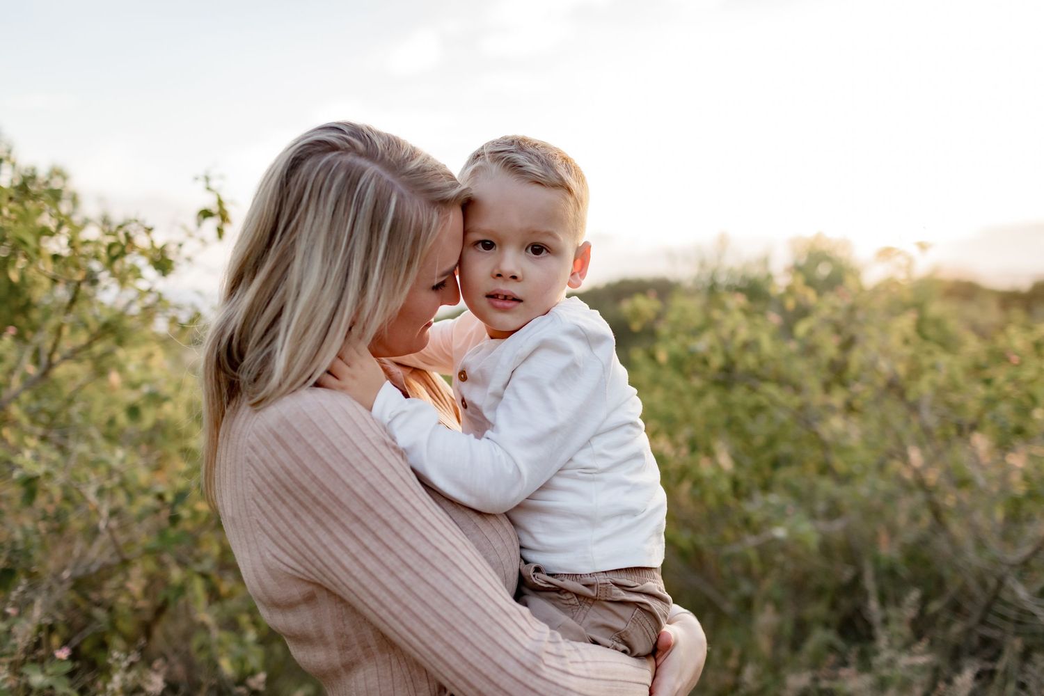 An intimate maternal moment shared between parent and child in natural lighting.