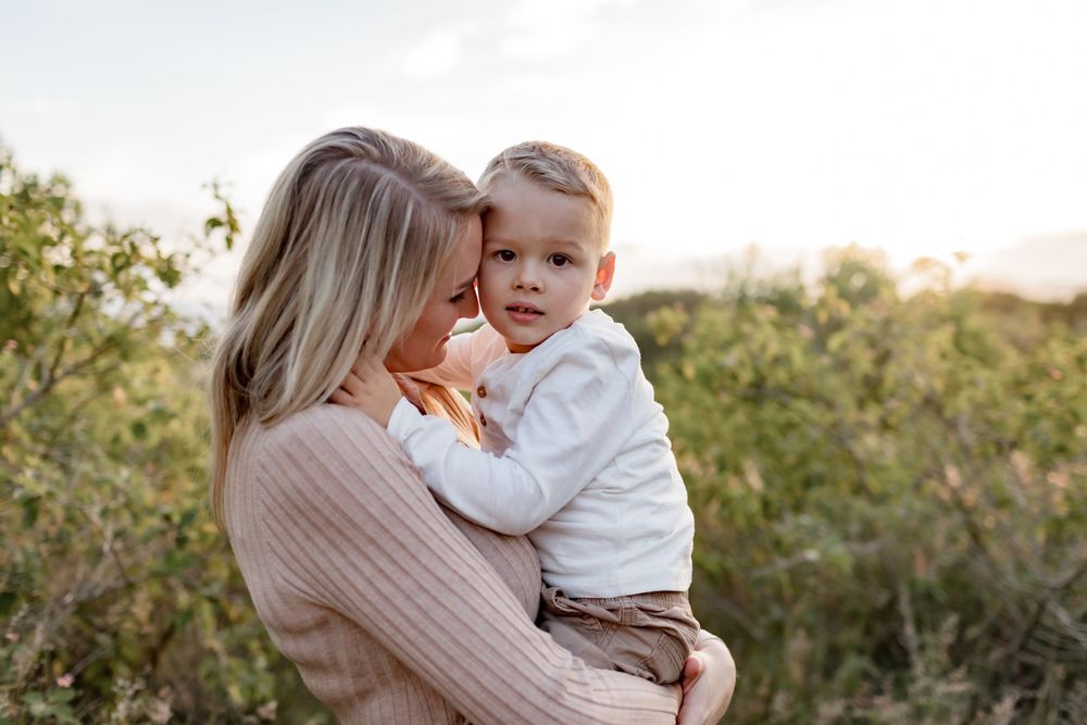 An intimate maternal moment shared between parent and child in natural lighting.