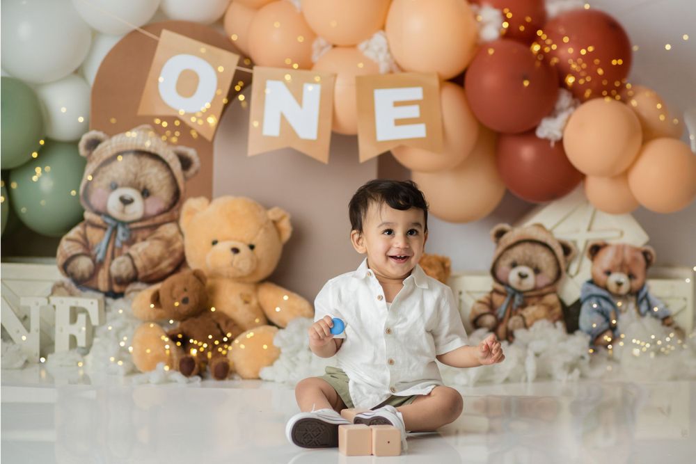 Rustic first birthday setup with teddy bears and neutral toned balloon arch.