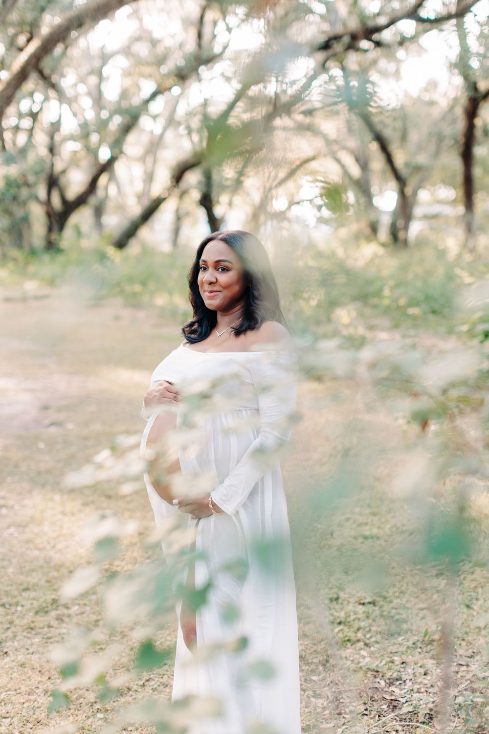 Pregnant woman holding her belly during an outdoor maternity photography session in Orlando