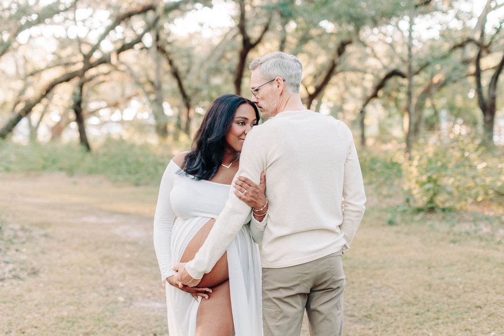 mom and dad to be holding each other and the belly during Orlando maternity photography session