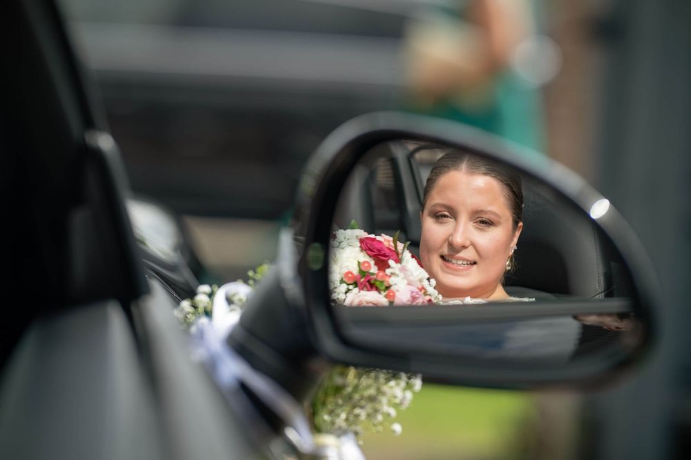 réflection de la mariée dans le rétroviseur de la voiture qui la conduit à l'église