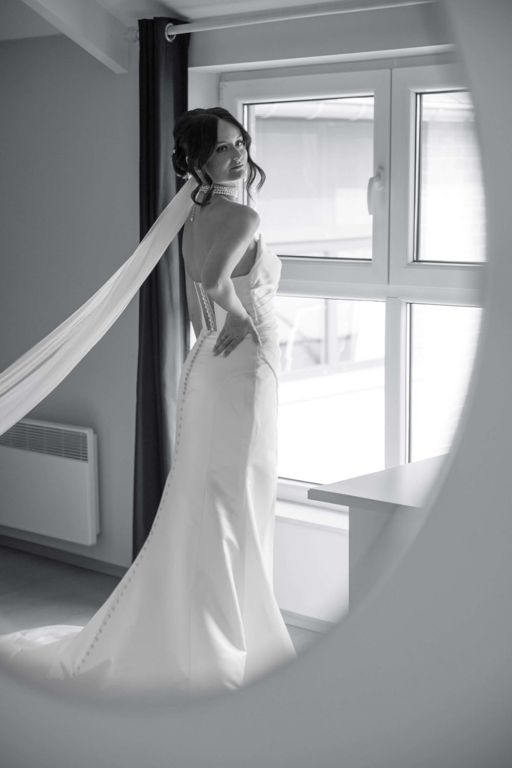 Reflet d'une mariée en noir et blanc dans un miroir prête à aller se marier.