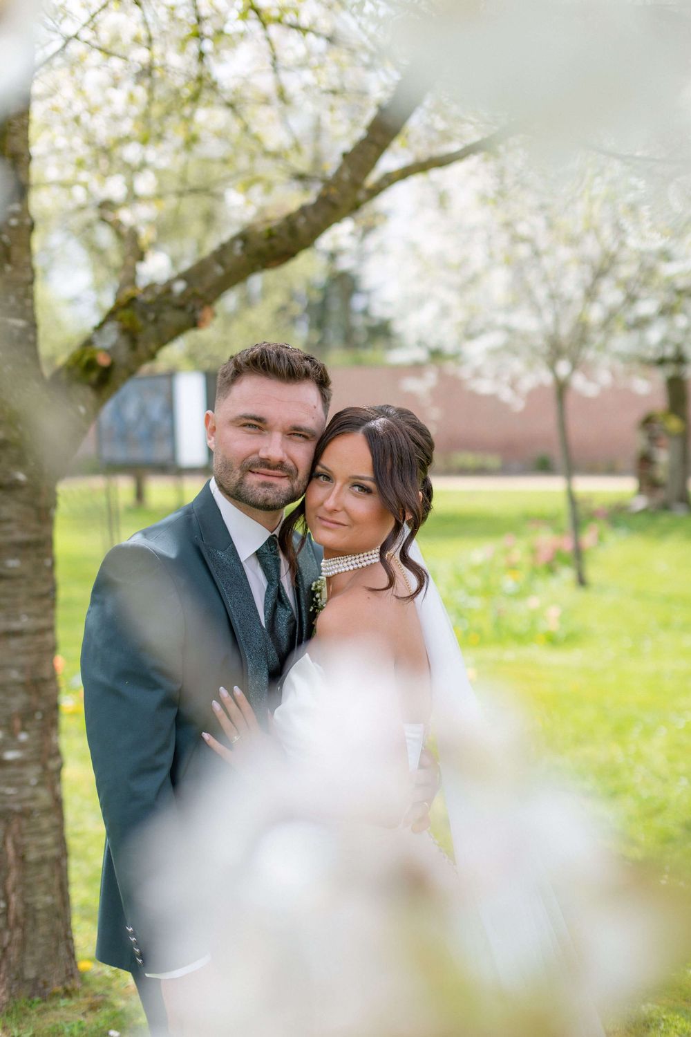 Le marié et la mariée en dessous d'un arbre en fleurs juste après s'être dit "oui" à la maison communale