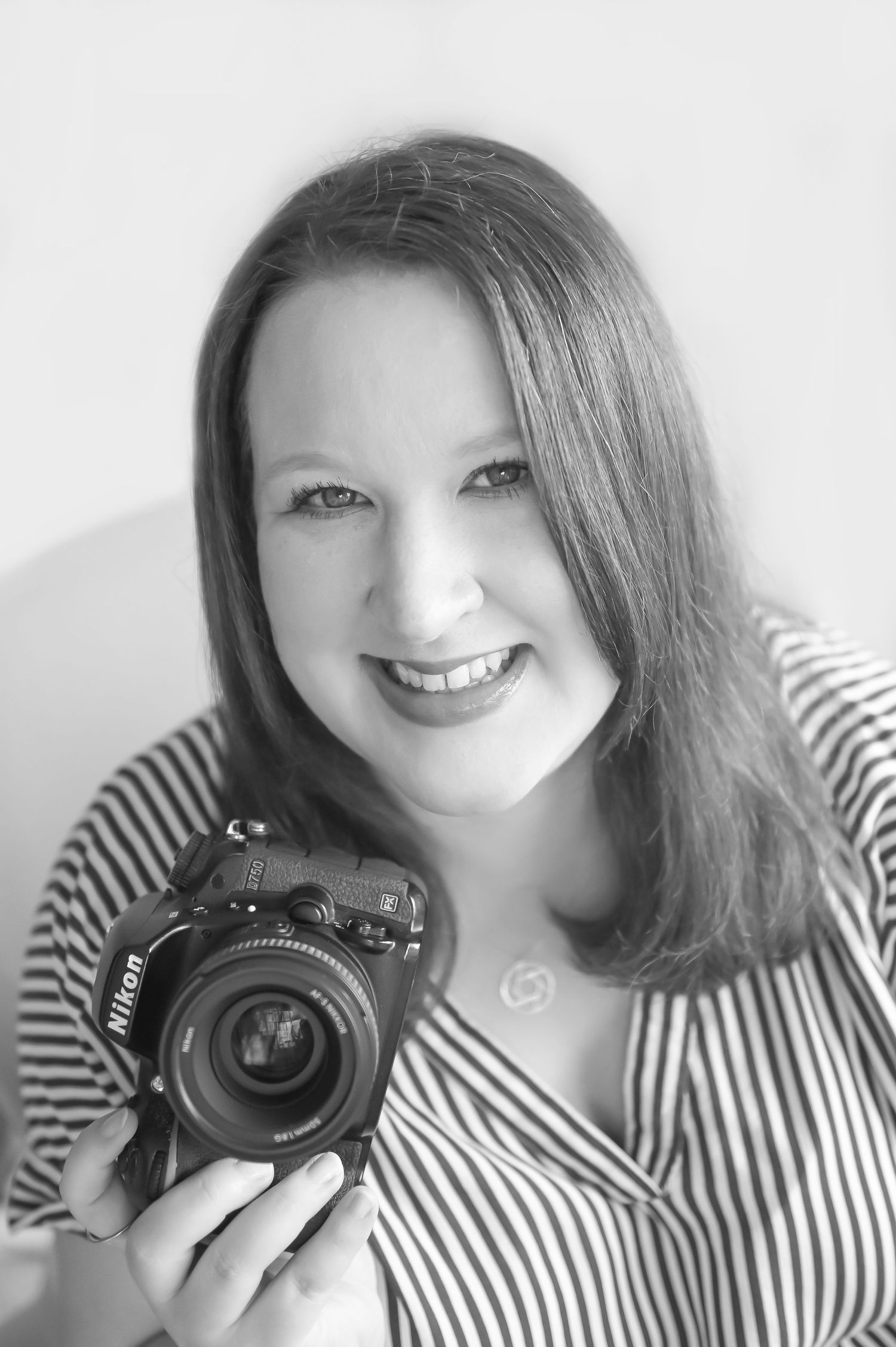 Series of black and white self portraits with camera in striped shirt.