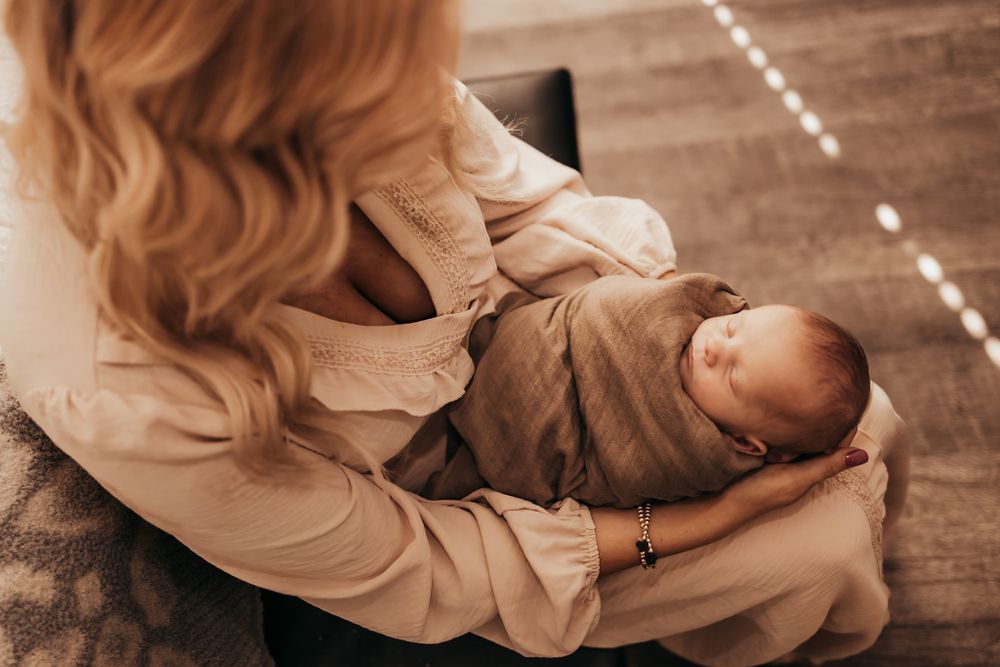 mom holding baby boy and looking down at him