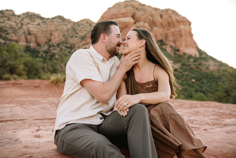 Couple sharing a romantic moment in Sedona, Arizona, with red rock formations in the background.