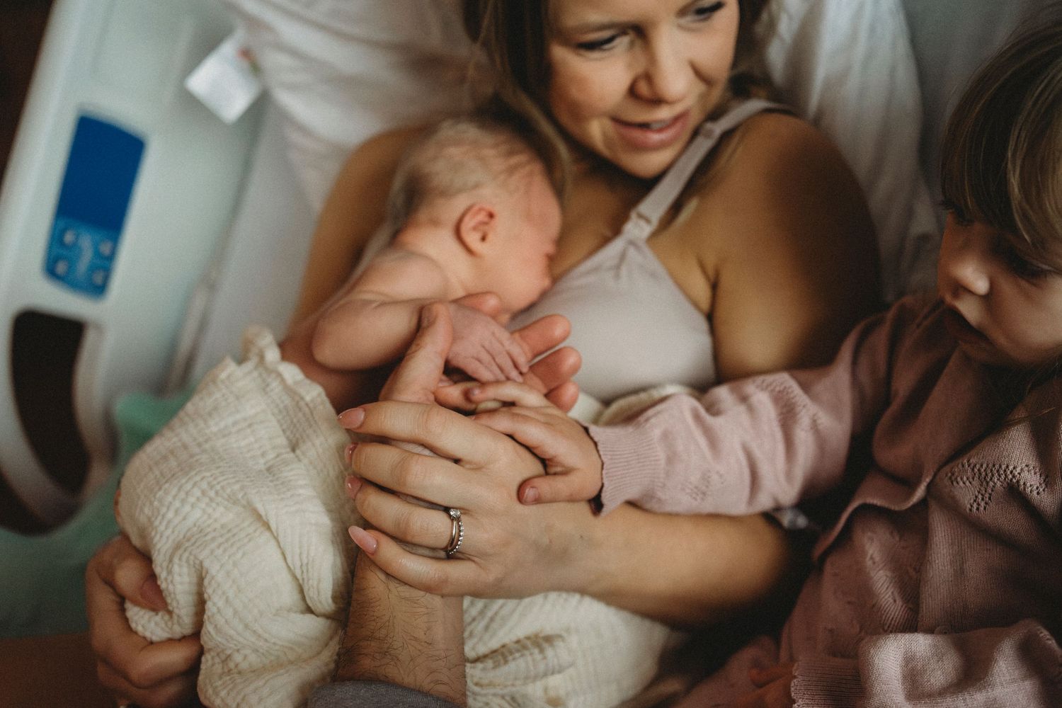 An intimate bonding moment captured in a hospital room with a newborn baby.