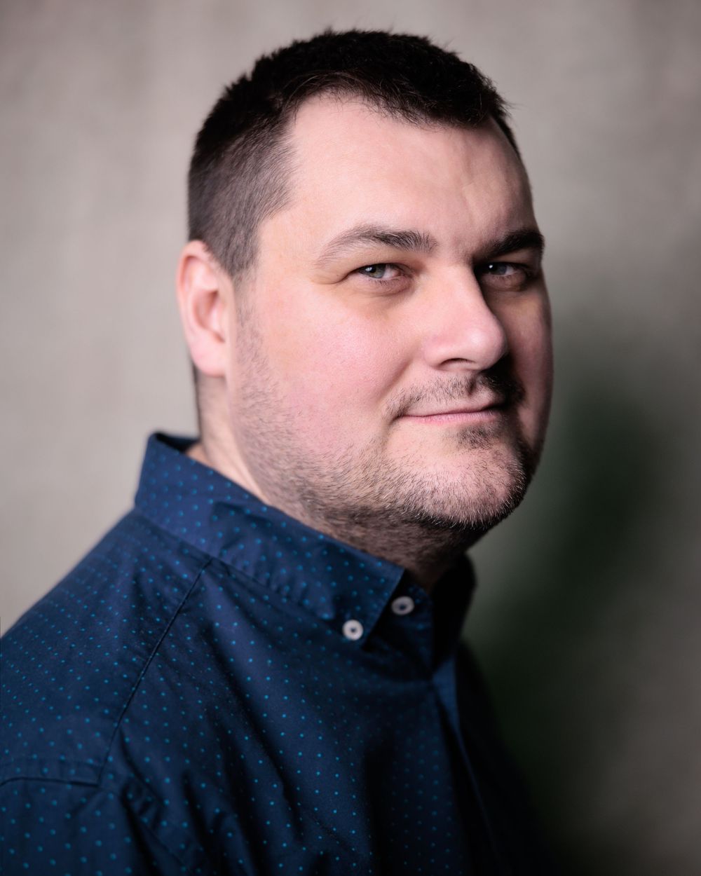 A series of portrait shots showing different angles of a person wearing a navy blue sweater against a blurred background.