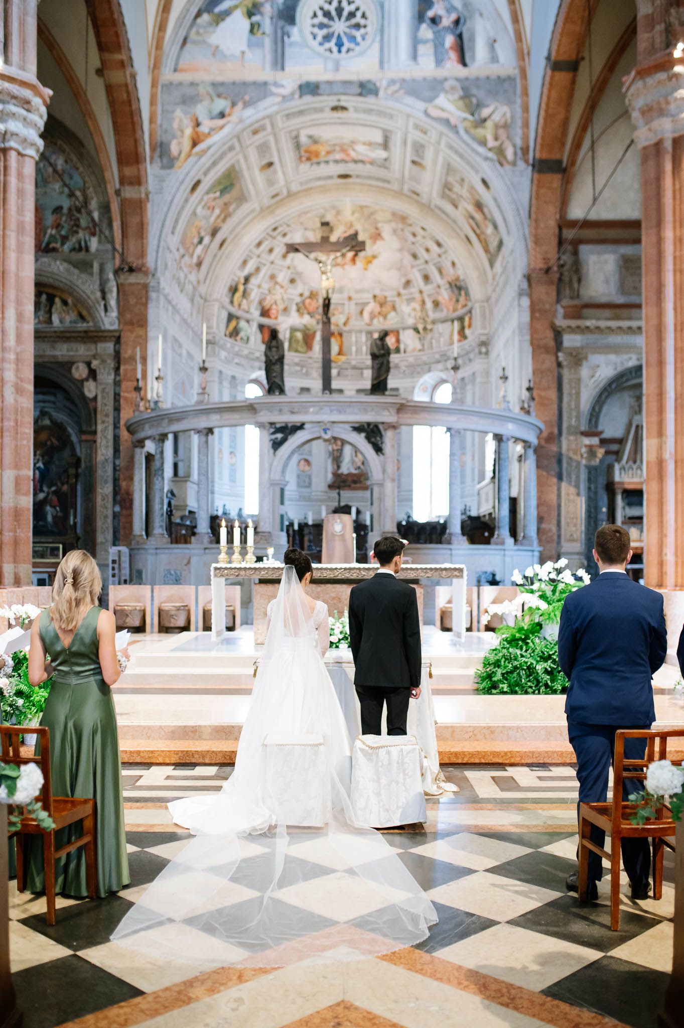 Beautiful church wedding ceremony in ornate cathedral with marble columns, vaulted ceiling and traditional decor.