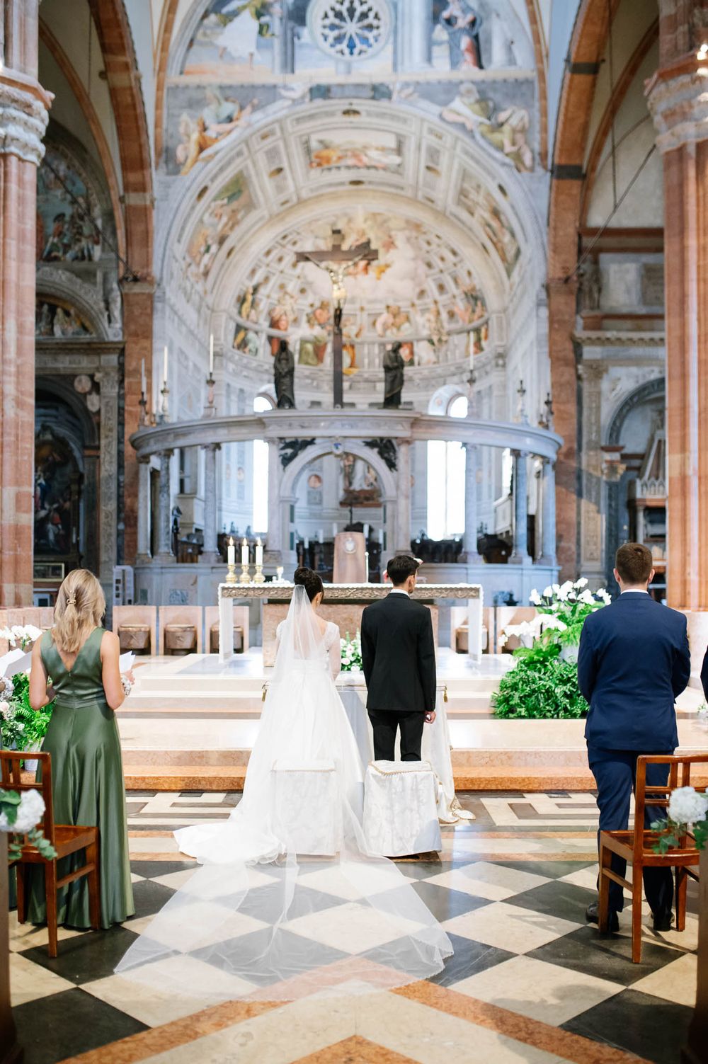 Beautiful church wedding ceremony in ornate cathedral with marble columns, vaulted ceiling and traditional decor.