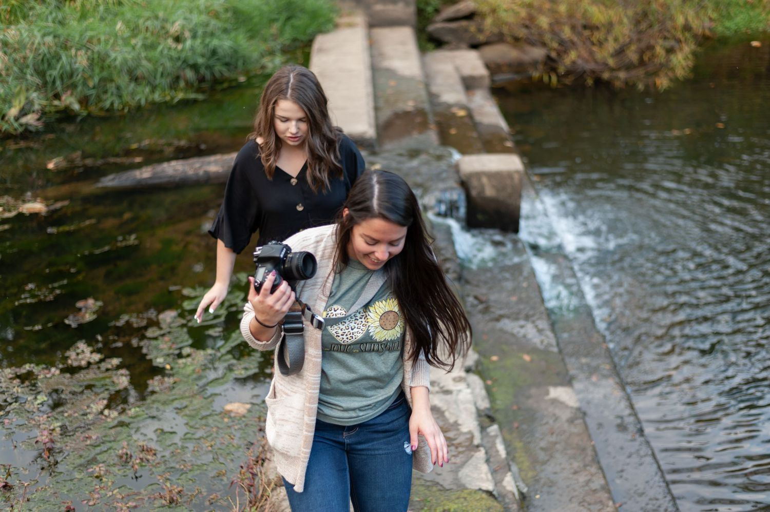Photographers capture creative angles at an outdoor stone structure.