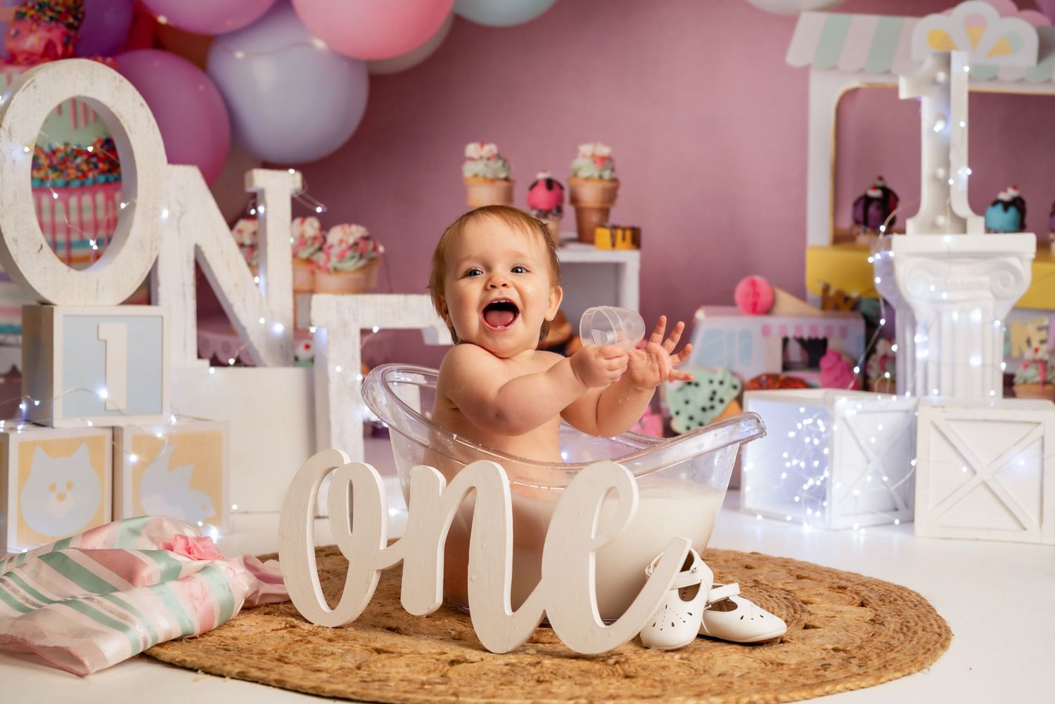 Festive first birthday party display with pastel balloons and decorative letters.