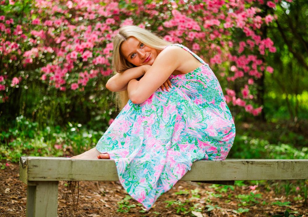 Playful spring portrait session with pink flowering azalea bushes.
