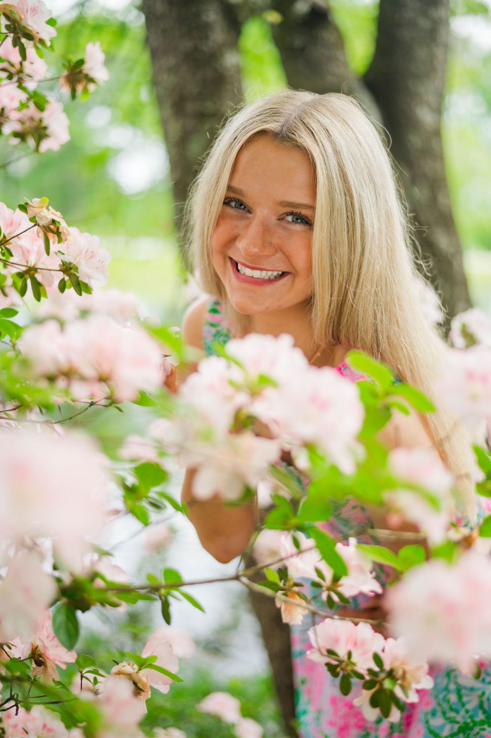 A cheerful springtime portrait surrounded by blooming pink cherry blossoms.