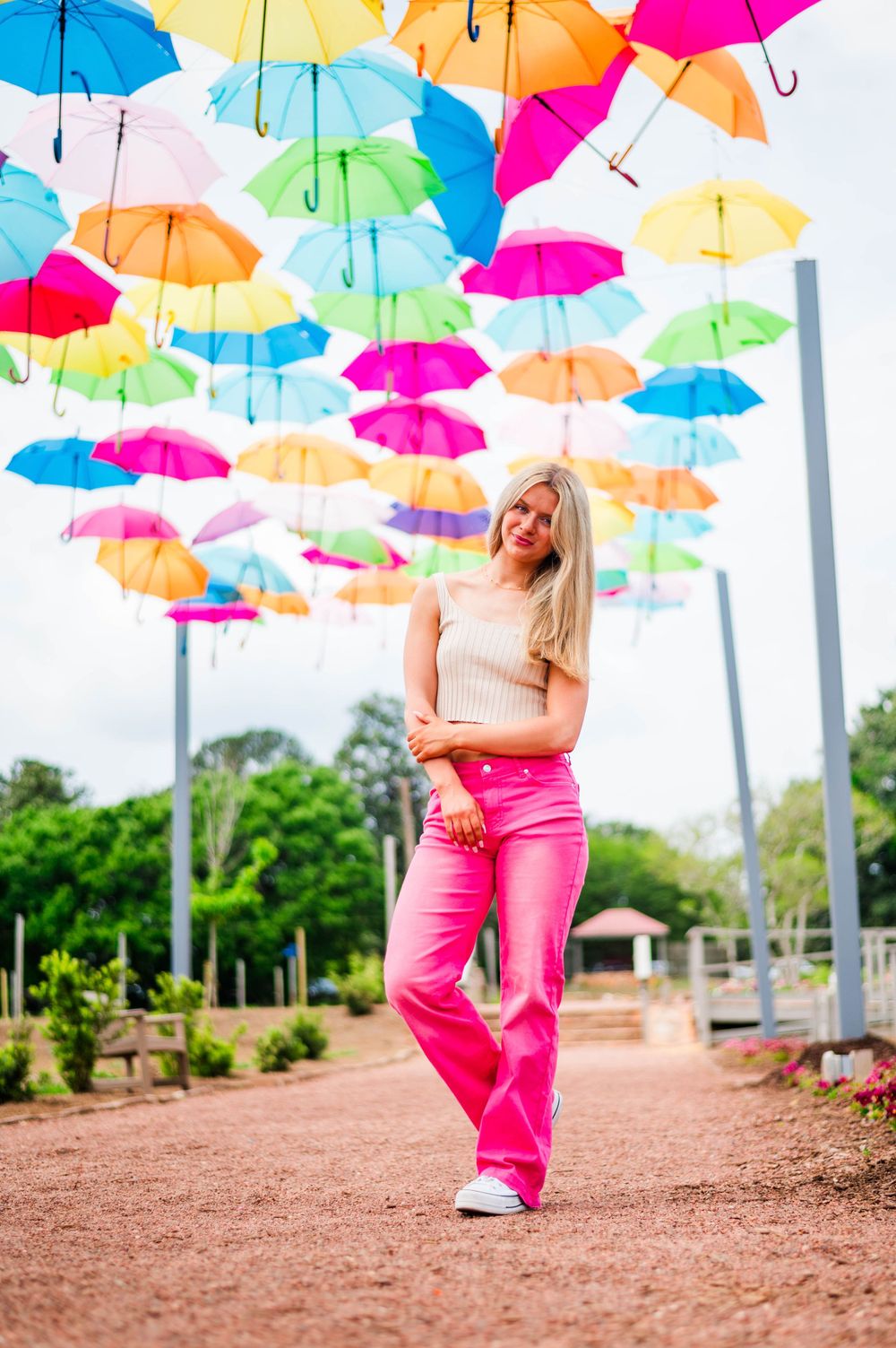 A casual outdoor photo beneath an art installation of colorful floating umbrellas.