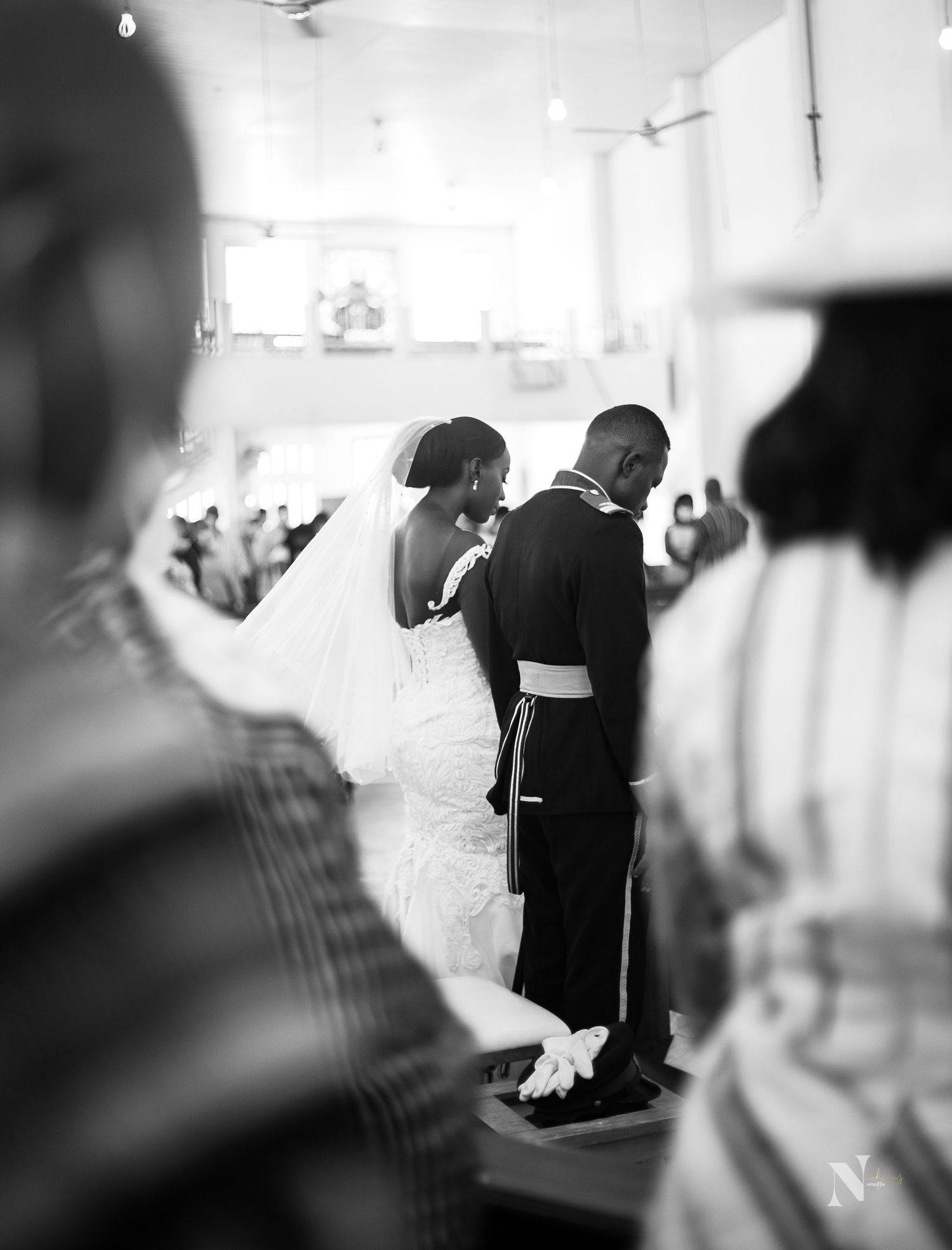 A black and white wedding ceremony photo capturing an intimate moment between newlyweds at the altar.