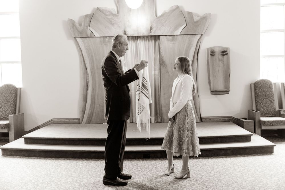 Black and white photograph of religious ceremony in front of decorative altar.