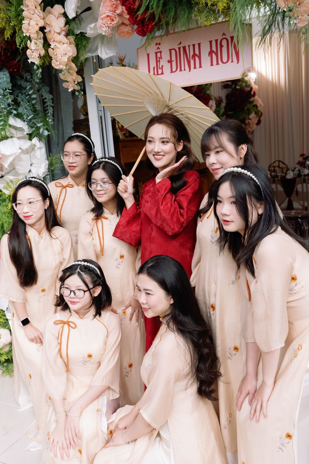 Traditional Vietnamese engagement ceremony with decorative floral arch and parasol accent.