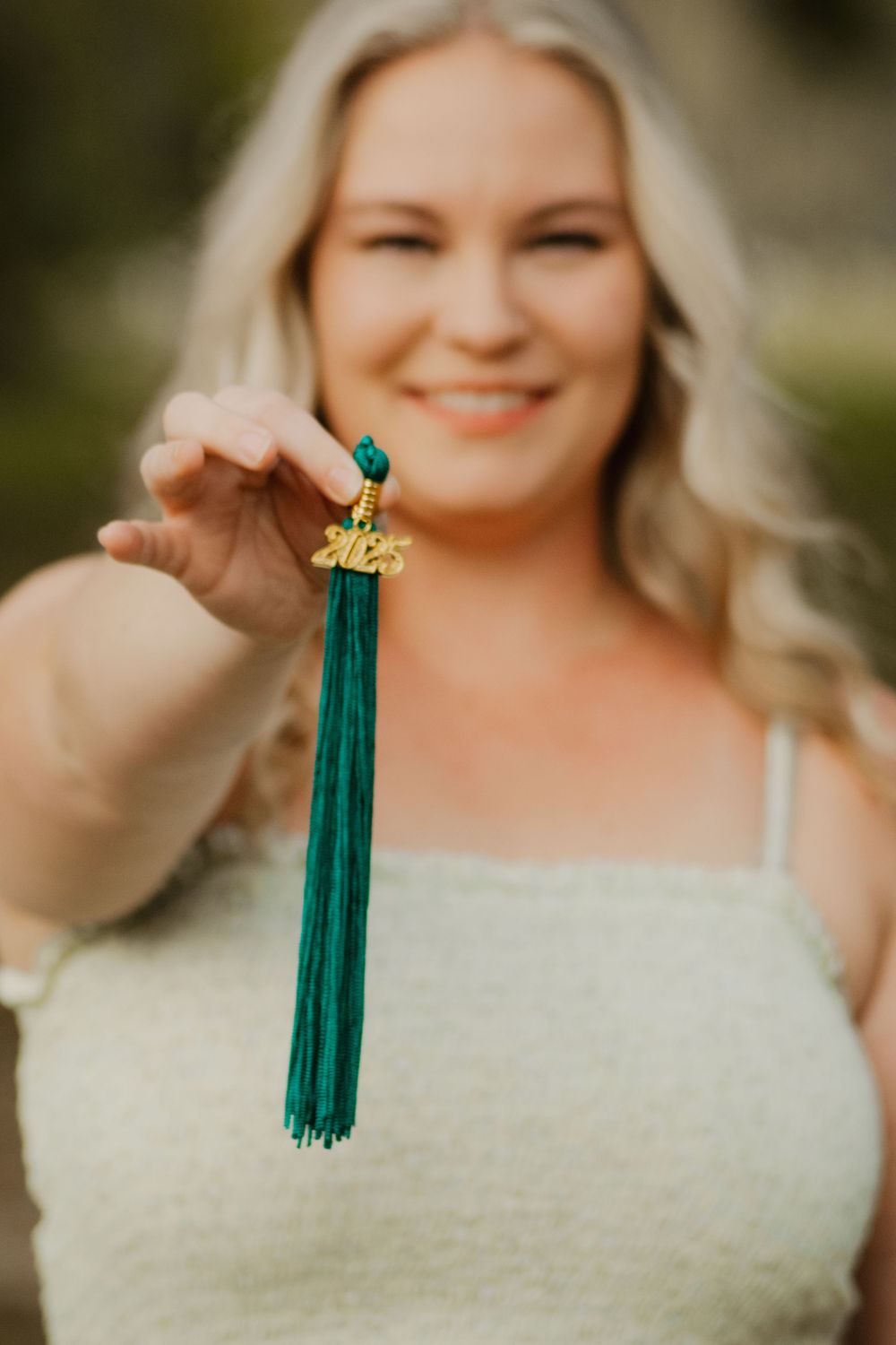 A series of photos showing a white lace wedding dress and an emerald green graduation tassel.
