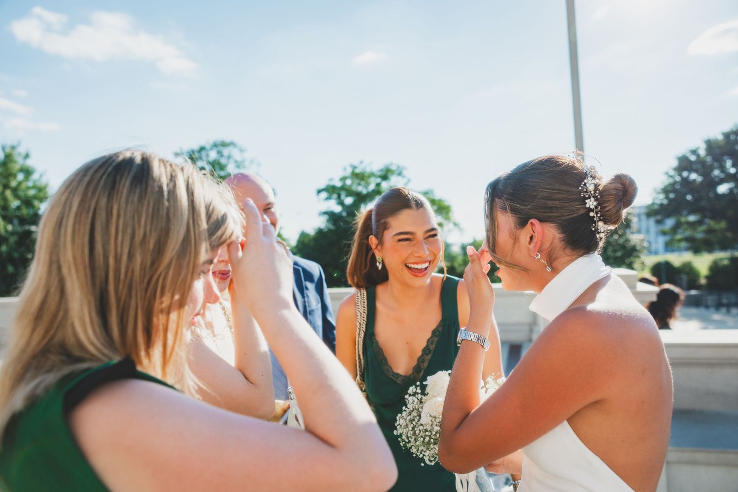 Wedding guests laugh and share joyful moments during outdoor celebration.
